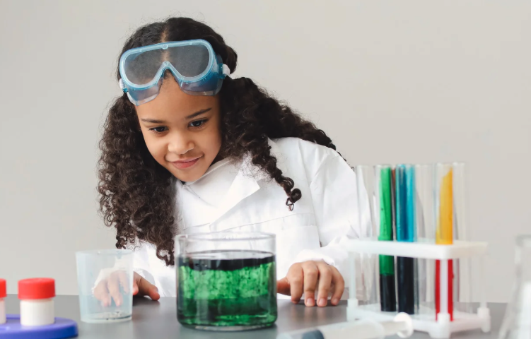 Little girl doing chemistry, watching bubbling potion. 