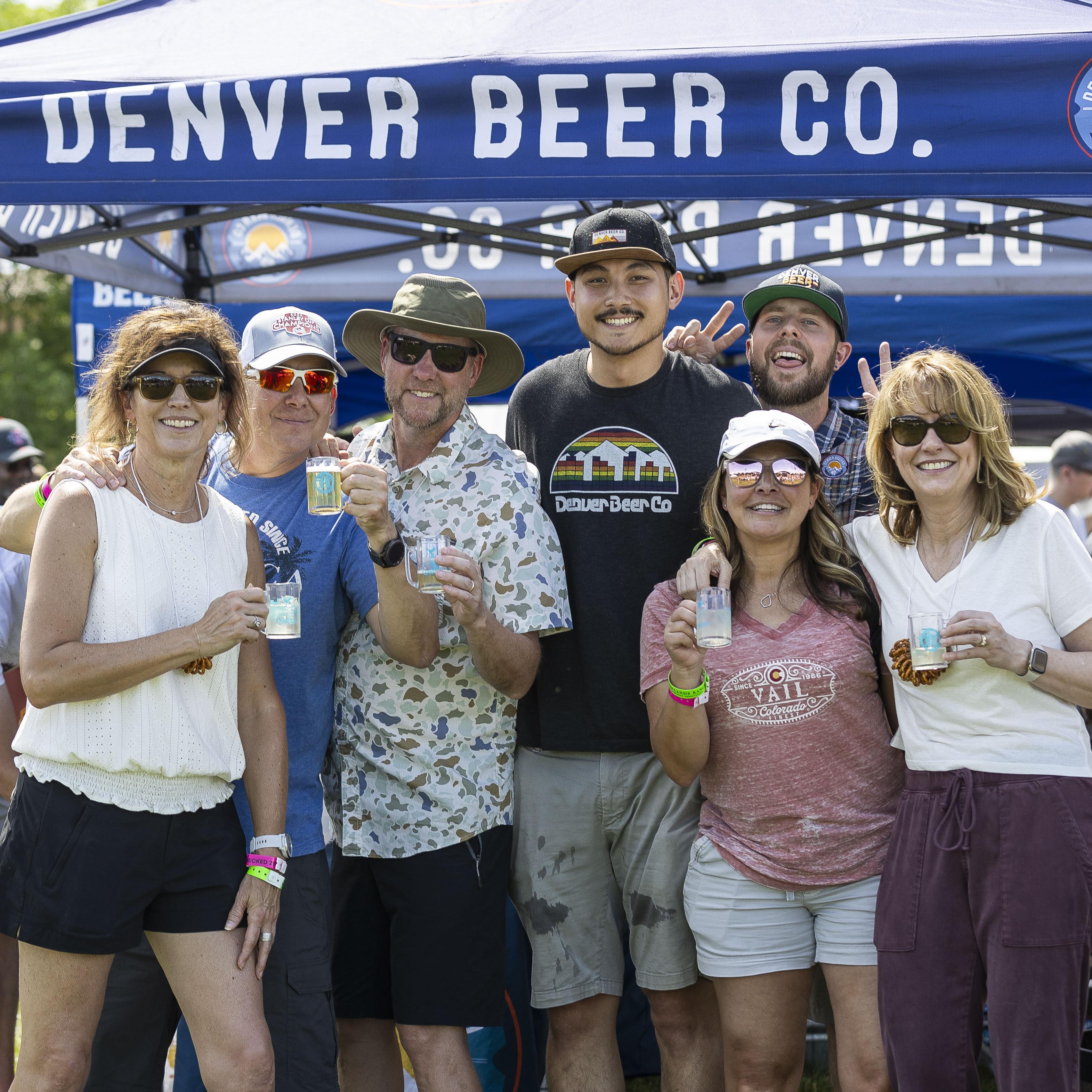 Group of people smiling in front of outdoor tent