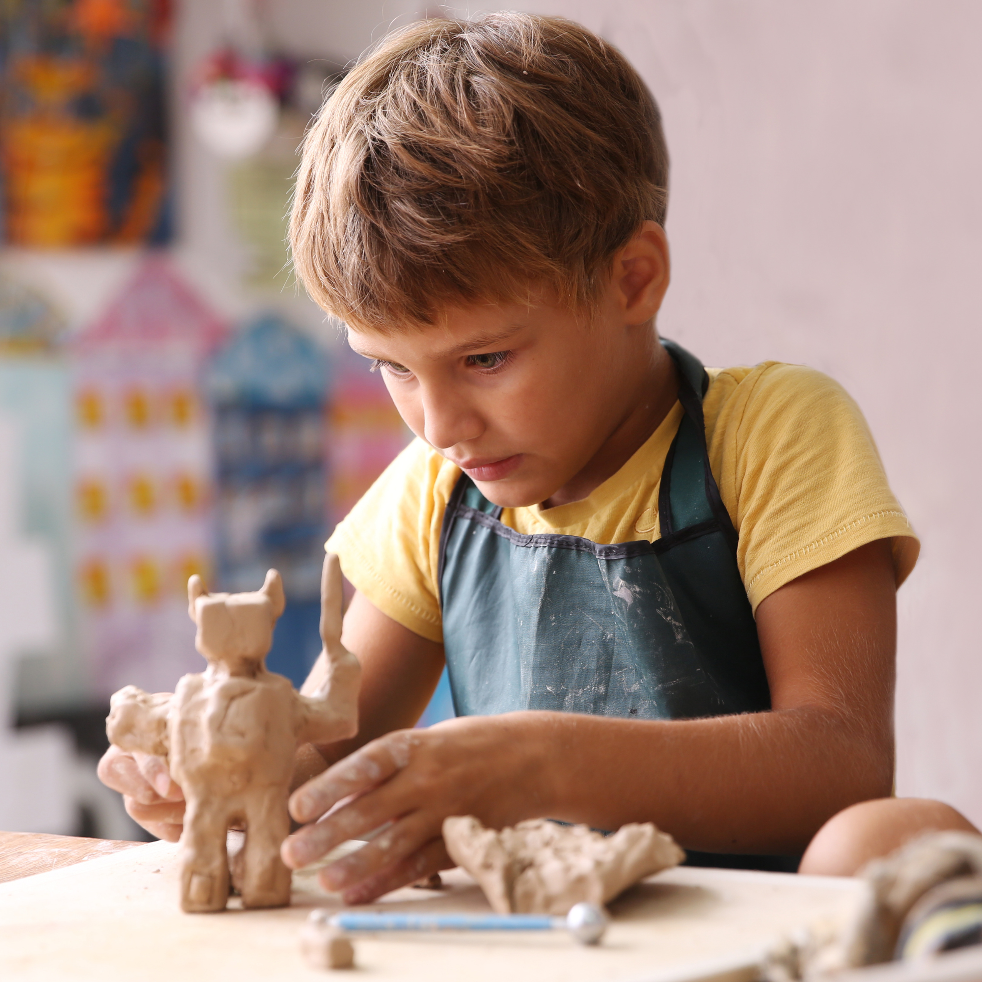 Child sculpting character with clay.