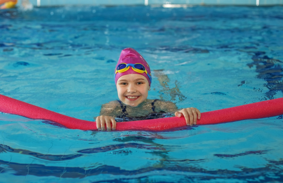 Girl in pool with pool noodle.